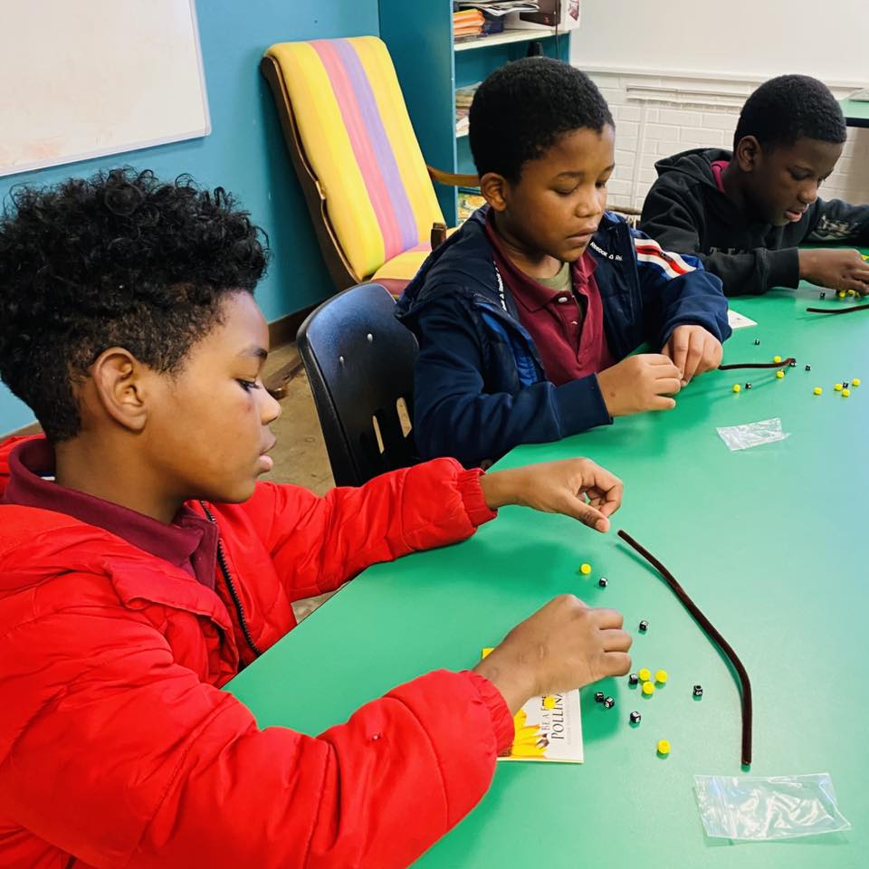 Two boys making bead bracelets.